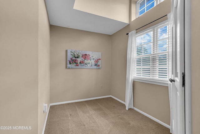 carpeted spare room featuring baseboards