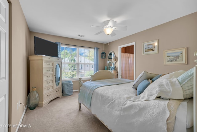 bedroom featuring light carpet, baseboards, and ceiling fan