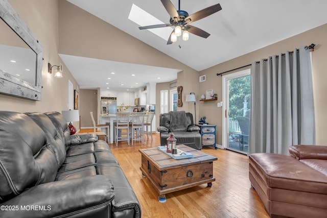 living room with a ceiling fan, light wood finished floors, recessed lighting, and high vaulted ceiling
