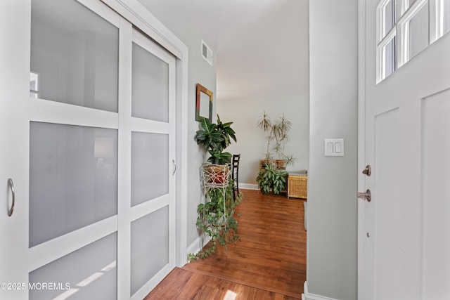 hallway featuring wood finished floors and baseboards