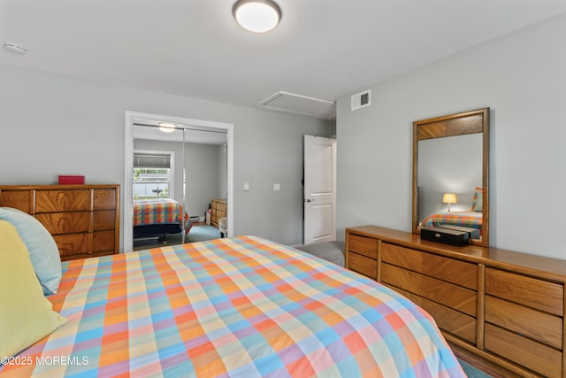 bedroom with a closet, attic access, and a baseboard radiator