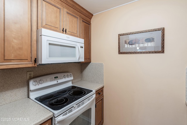 1154A Argyll Cir, Lakewood, NJ 08701 - kitchen with white appliances, light countertops, and brown cabinetry