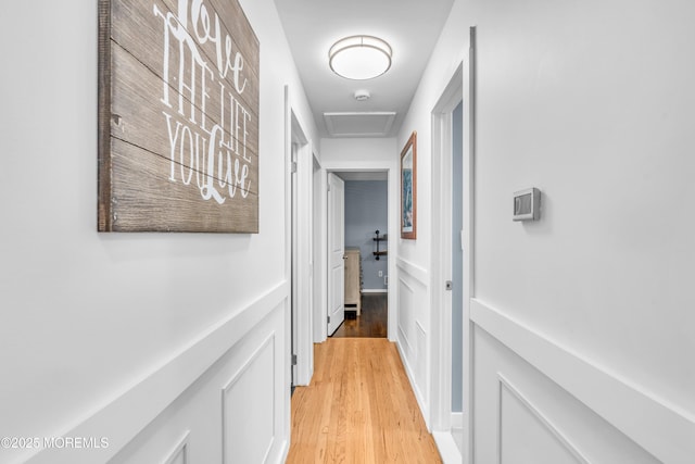 hall featuring attic access and light wood-style flooring