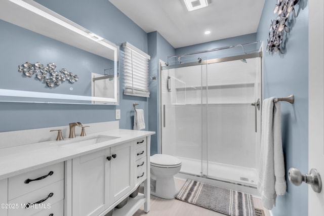 bathroom featuring a stall shower, vanity, toilet, and recessed lighting