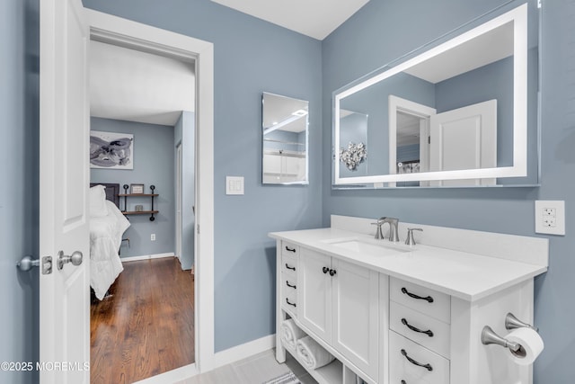 ensuite bathroom featuring baseboards and vanity