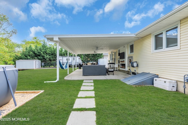 view of yard featuring a storage shed, a patio area, an outbuilding, outdoor lounge area, and a ceiling fan