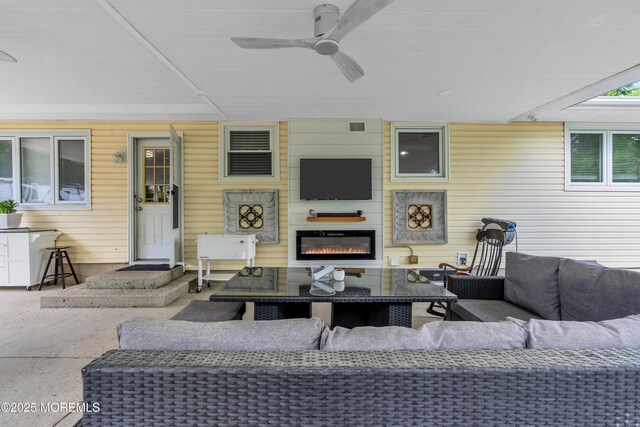 view of patio with an outdoor living space with a fireplace and ceiling fan