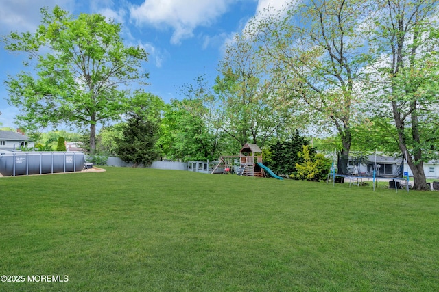 view of yard featuring a trampoline and a playground