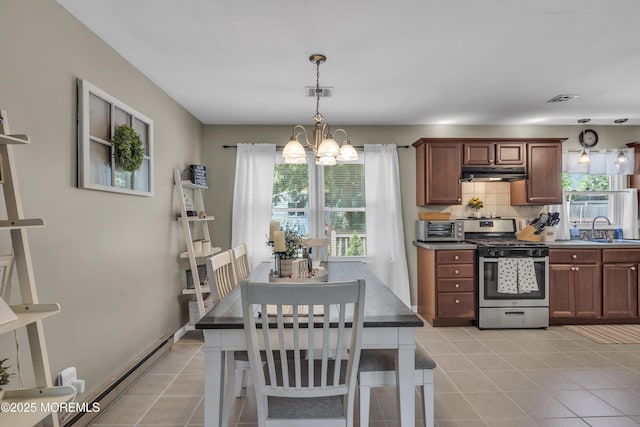 2465 Woodland Rd, Manchester, NJ 08759 - kitchen featuring gas stove, under cabinet range hood, a chandelier, decorative backsplash, and light tile patterned flooring