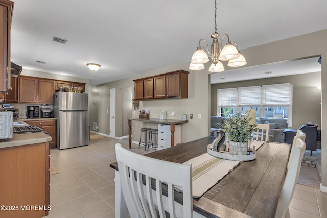 2465 Woodland Rd, Manchester, NJ 08759 - dining area with light tile patterned floors, a chandelier, and baseboards