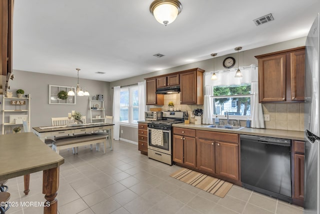 2465 Woodland Rd, Manchester, NJ 08759 - kitchen with appliances with stainless steel finishes, a sink, decorative backsplash, a chandelier, and hanging light fixtures