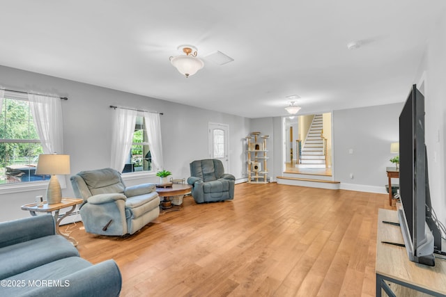 1042 Maxim Southard Rd, Howell, NJ 07731 - living area featuring stairs, healthy amount of natural light, light wood-style floors, and baseboards