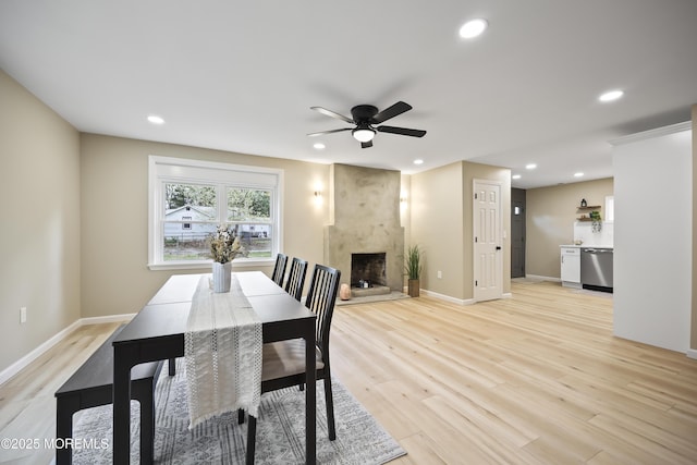 dining area with ceiling fan, recessed lighting, a fireplace, light wood finished floors, and baseboards
