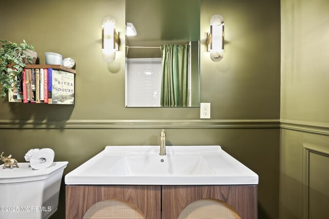 bathroom featuring toilet, vanity, and a shower with shower curtain