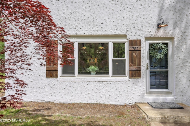 doorway to property with stucco siding