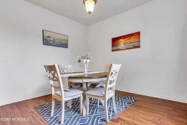 dining space with wood finished floors and baseboards