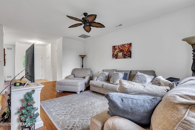 living room with wood finished floors and a ceiling fan