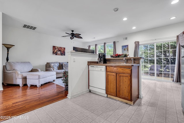 kitchen featuring dishwasher, brown cabinets, open floor plan, a ceiling fan, and recessed lighting