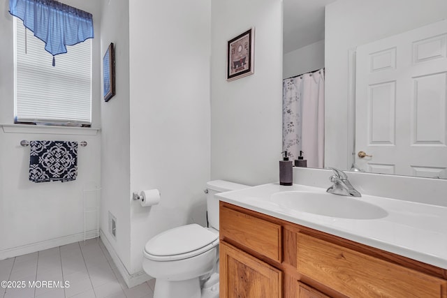 bathroom featuring tile patterned floors, toilet, vanity, and baseboards