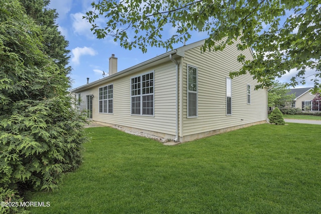 view of property exterior featuring a chimney and a lawn