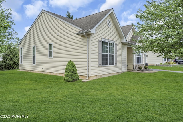 view of property exterior featuring a yard and a shingled roof
