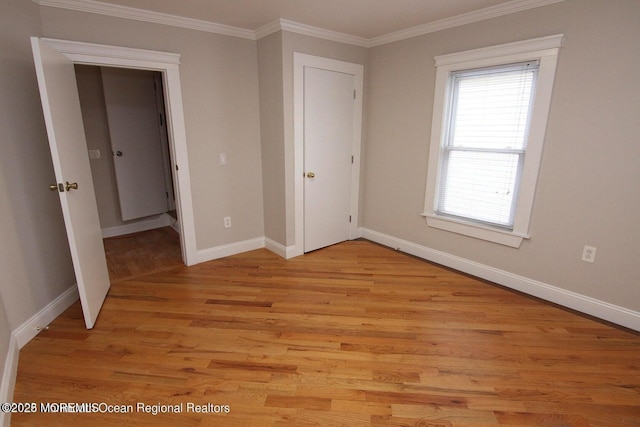unfurnished bedroom featuring baseboards, light wood finished floors, and crown molding