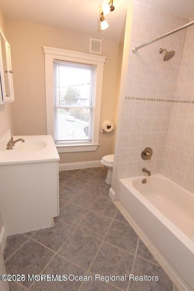bathroom with tile patterned flooring, toilet, shower / tub combination, baseboards, and vanity