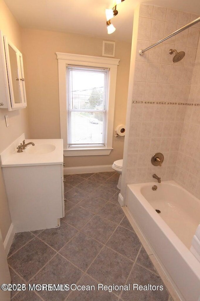 full bathroom featuring tile patterned floors, baseboards, toilet, vanity, and shower / bath combination