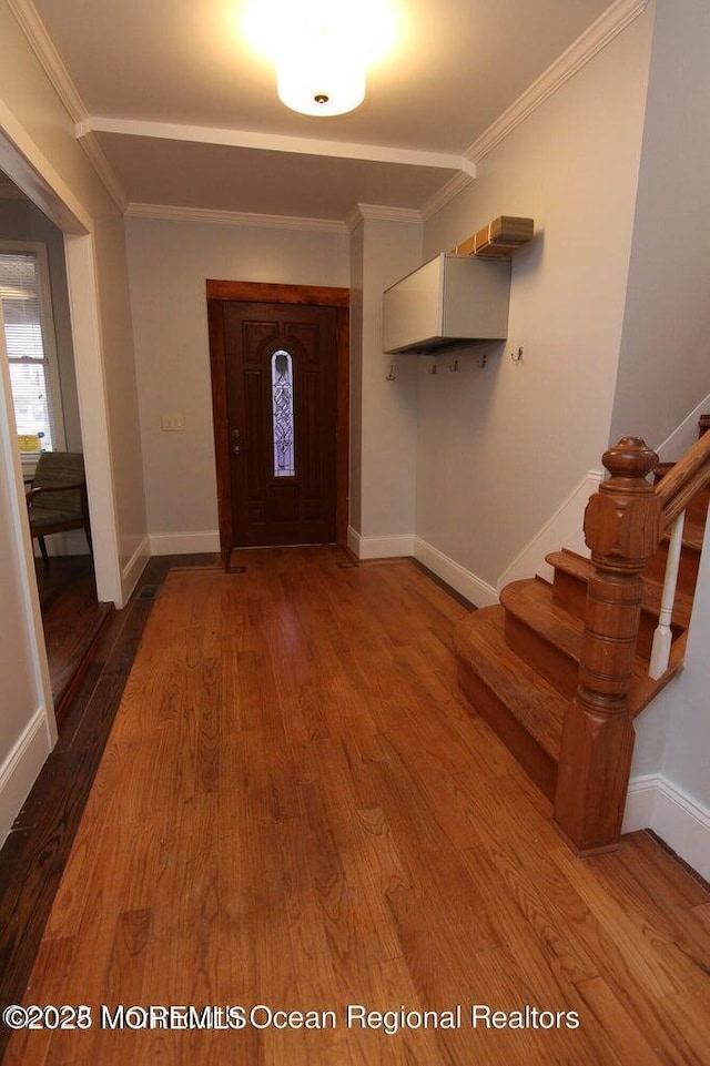 entryway featuring wood finished floors, stairway, crown molding, and baseboards