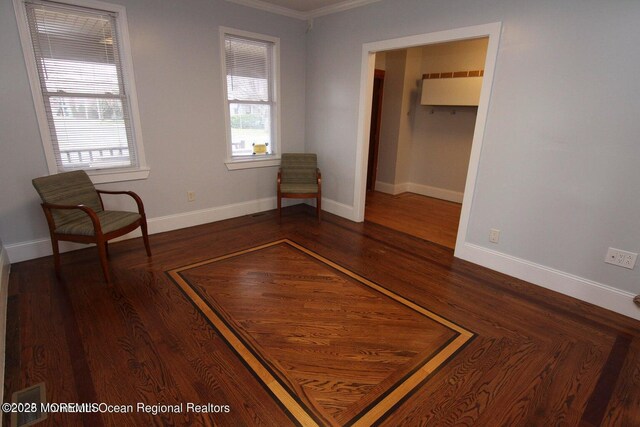 unfurnished room with crown molding, baseboards, and dark wood-style flooring