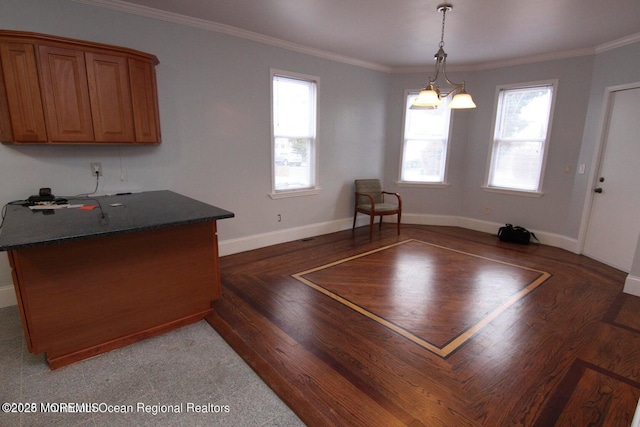 dining room with light wood-style flooring, healthy amount of natural light, baseboards, and crown molding