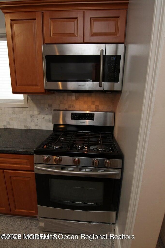 kitchen with appliances with stainless steel finishes, decorative backsplash, and brown cabinetry