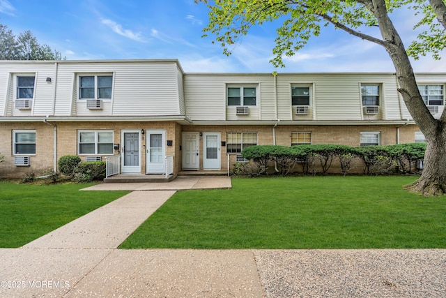 view of property featuring brick siding and a front lawn