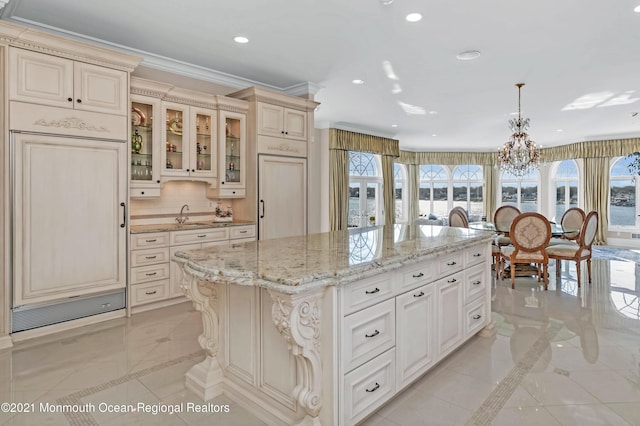 1015 Forrest Rd, Brielle, NJ 08730 - kitchen featuring inlaid floor details, a sink, a chandelier, cream cabinetry, and a kitchen island