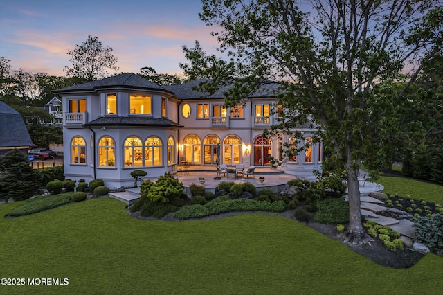1015 Forrest Rd, Brielle, NJ 08730 - back of property at dusk featuring a patio area, a yard, stucco siding, and a balcony