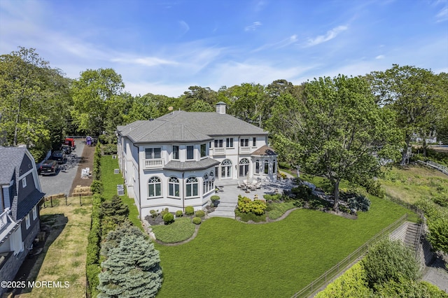 1015 Forrest Rd, Brielle, NJ 08730 - back of house featuring a balcony, a lawn, view of scattered trees, and a chimney