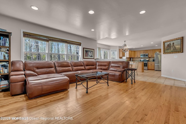 living area with recessed lighting, a chandelier, and light wood-style flooring