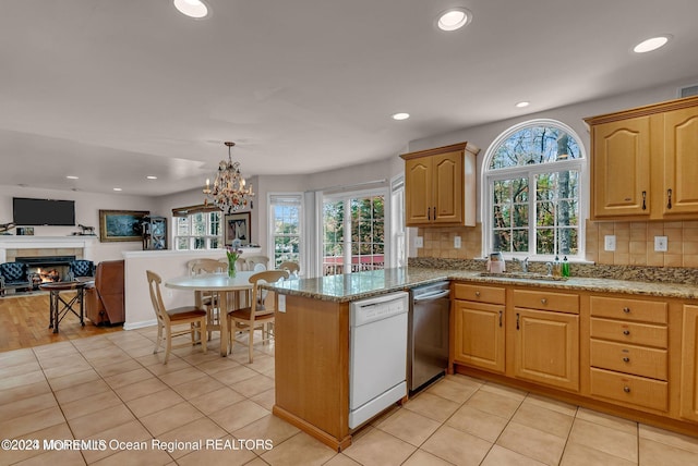 kitchen featuring stainless steel dishwasher, dishwasher, a sink, decorative backsplash, and open floor plan