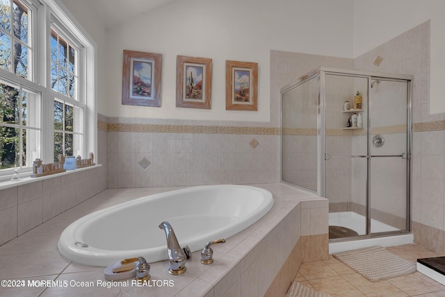 bathroom featuring a stall shower, vaulted ceiling, a garden tub, and tile patterned floors