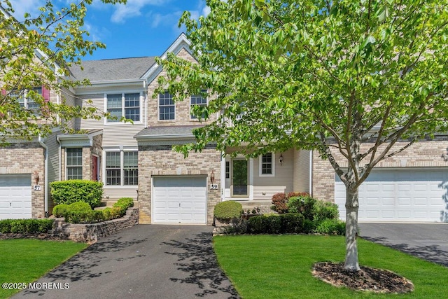59 Inwood Dr, Manalapan, NJ 07726 - view of front of house with asphalt driveway, a front yard, an attached garage, and brick siding