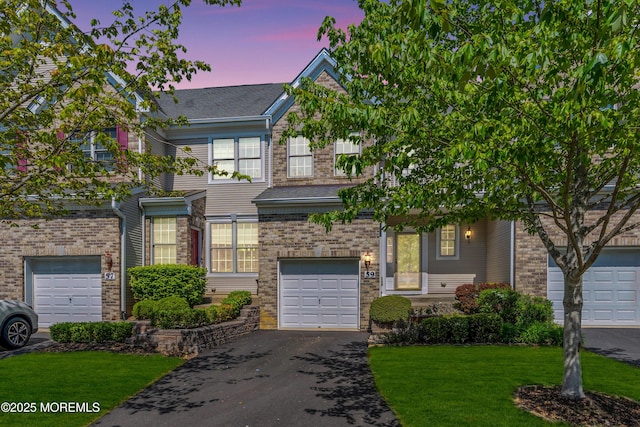 59 Inwood Dr, Manalapan, NJ 07726 - view of front of house with driveway, an attached garage, a front yard, and brick siding