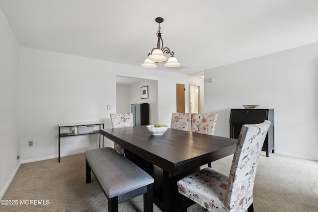 dining area with light colored carpet, baseboards, and a chandelier