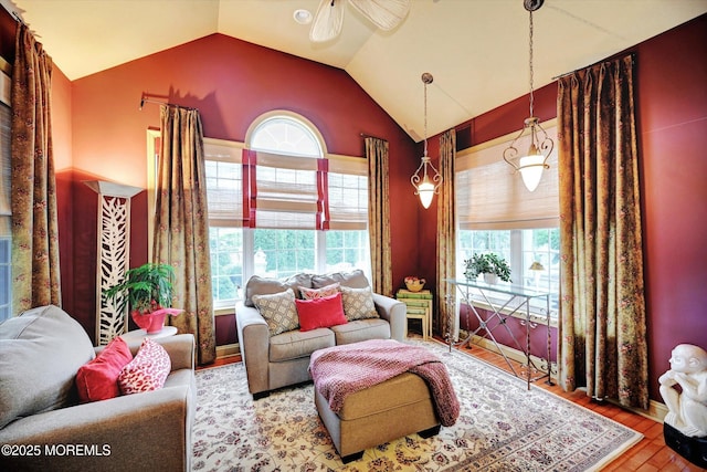 living area with a ceiling fan, wood finished floors, and high vaulted ceiling