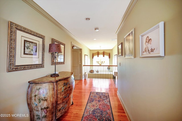 hall featuring light wood-style flooring, crown molding, baseboards, and recessed lighting