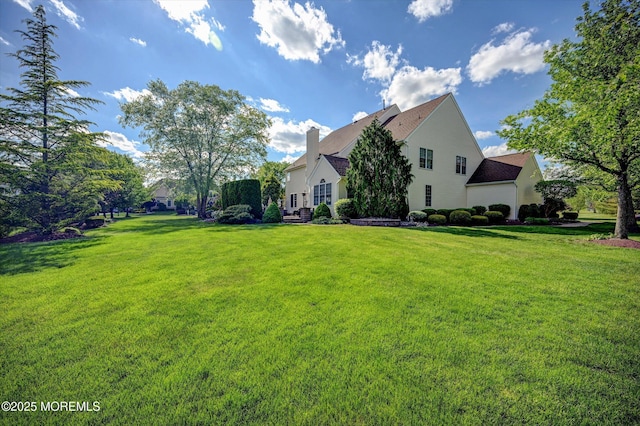 view of side of property with a yard and a chimney