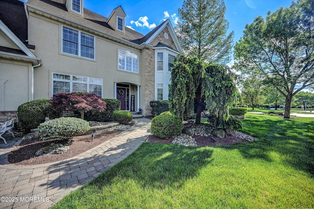 view of front of house with stone siding, stucco siding, and a front yard