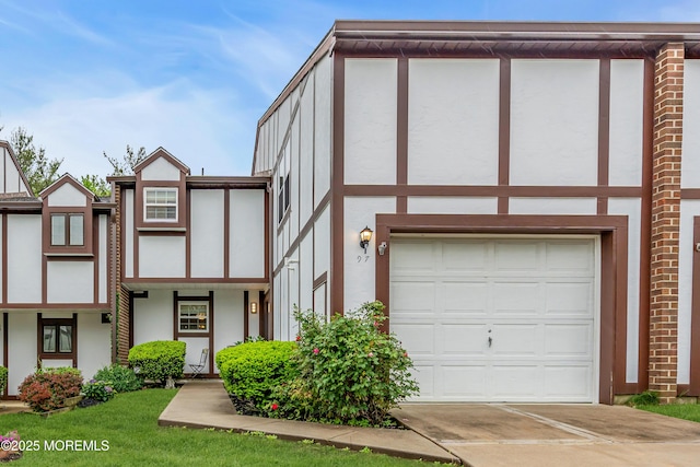 view of front of home with stucco siding, driveway, and an attached garage
