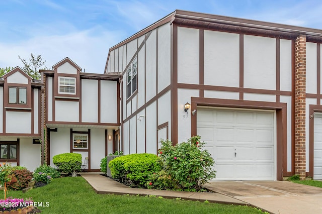 tudor-style house featuring stucco siding, driveway, and an attached garage