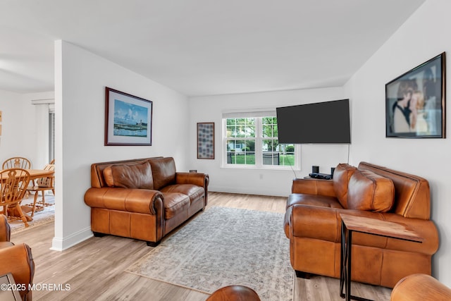 living area featuring light wood-style floors and baseboards