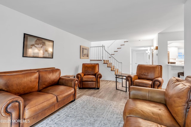 living area featuring stairway and light wood-style flooring